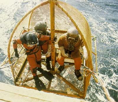  trainee divers are lowered into the water during the special 16-week standard-dress course at the Norwegian State Diving School. This equipment is still widely used in Norwegian onshore work, particularly during construction of oil terminals.